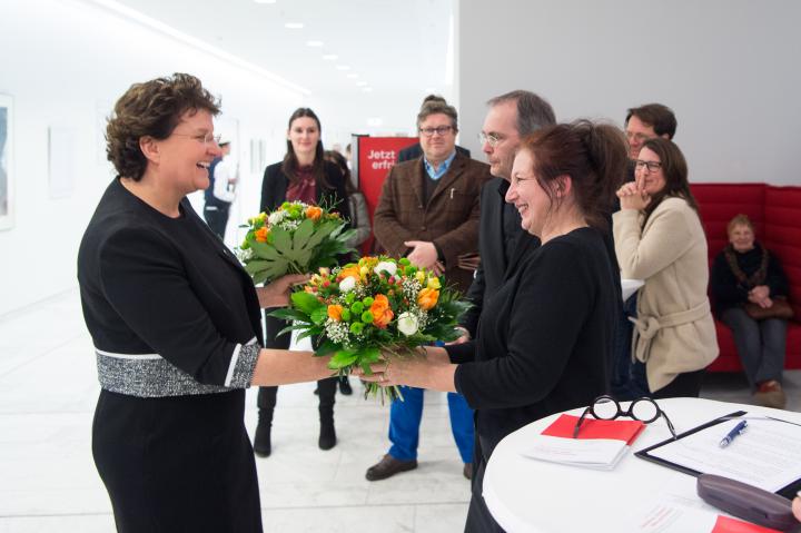 Landtagspräsidentin Britta Stark (l.) überreicht Blumensträuße an Ulrike Kremeier und Armin Hauer