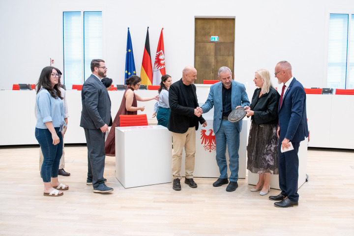 Feierliche Überreichung einer Plakete aus Bronze an die Preisträgerinnen und Preisträger European Heritage Volunteers durch Prof. Dr. Hermann Parzinger (3. v. r.), Barbara Gessler (2. v. r.) und Dr. Uwe Koch (1. v. r.).
