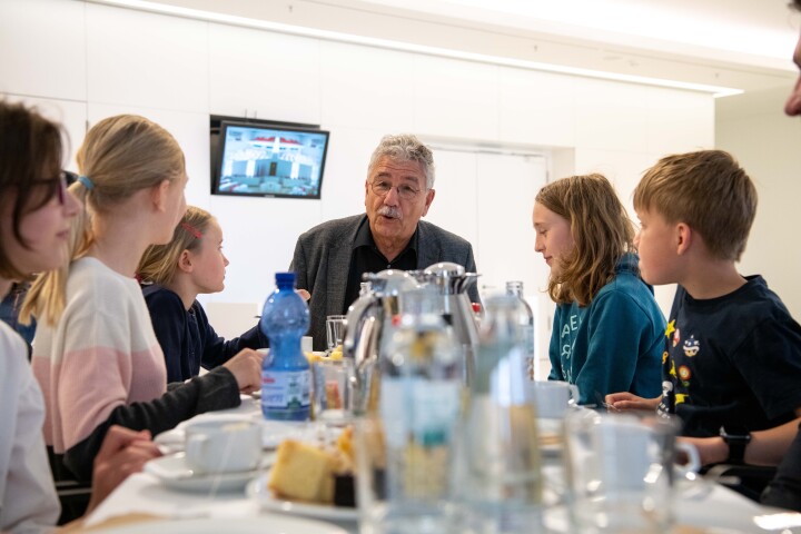 Der Abgeordnete Helmut Barthel und Kinder an der Kuchen- und Kakaotafel im gemeinsamen Gespräch.