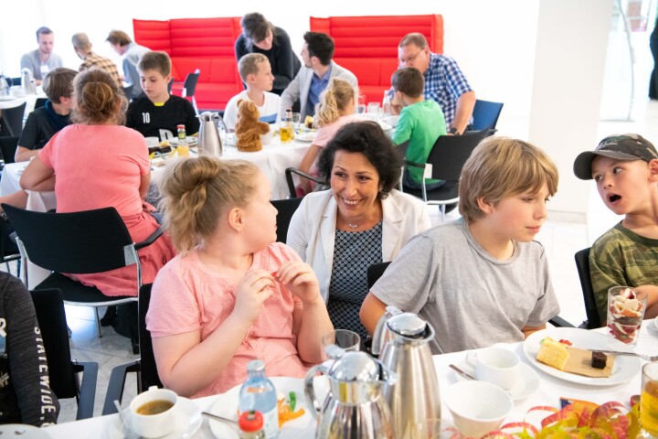 Die Abgeordnete Kristy Augustin und Kinder an der Kuchen- und Kakaotafel im gemeinsamen Gespräch.
