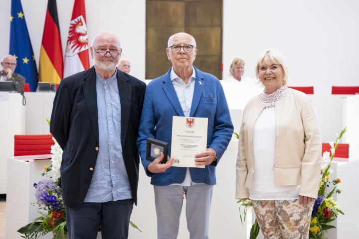 V.l.n.r. Abgeordneter Reinhard Simon (BSW-Fraktion), Träger der Medaille Armin Paul Georg Schubert und Landtagspräsidentin Prof. Dr. Ulrike Liedtke
