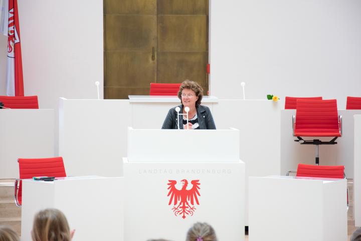 Landtagspräsidentin Britta Stark begrüßt zur Kindertagsfeier im Plenarsaal.
