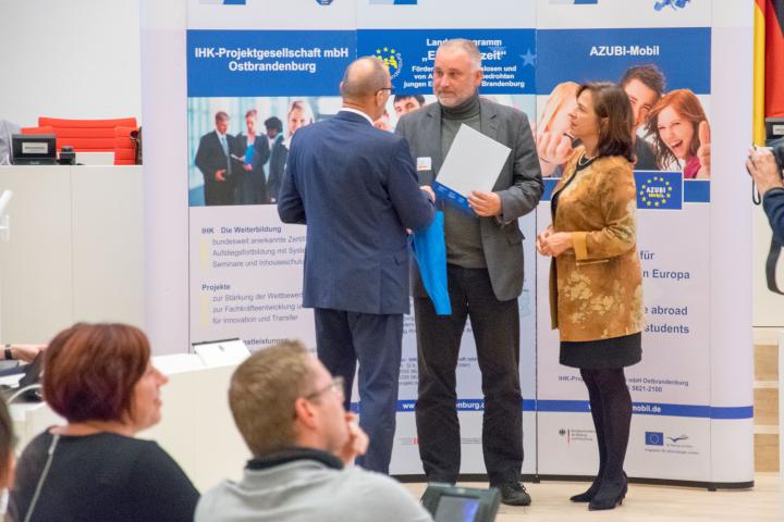 Vizepräsidentin Barbara Richstein (r.) überreicht gemeinsam mit dem Geschäftsführer der IHK Projektgesellschaft mbH Ostbrandenburg, Herrn Peter Wölffling (l.), Unternehmen die Auszeichnung „Berufsbildung ohne Grenzen“.