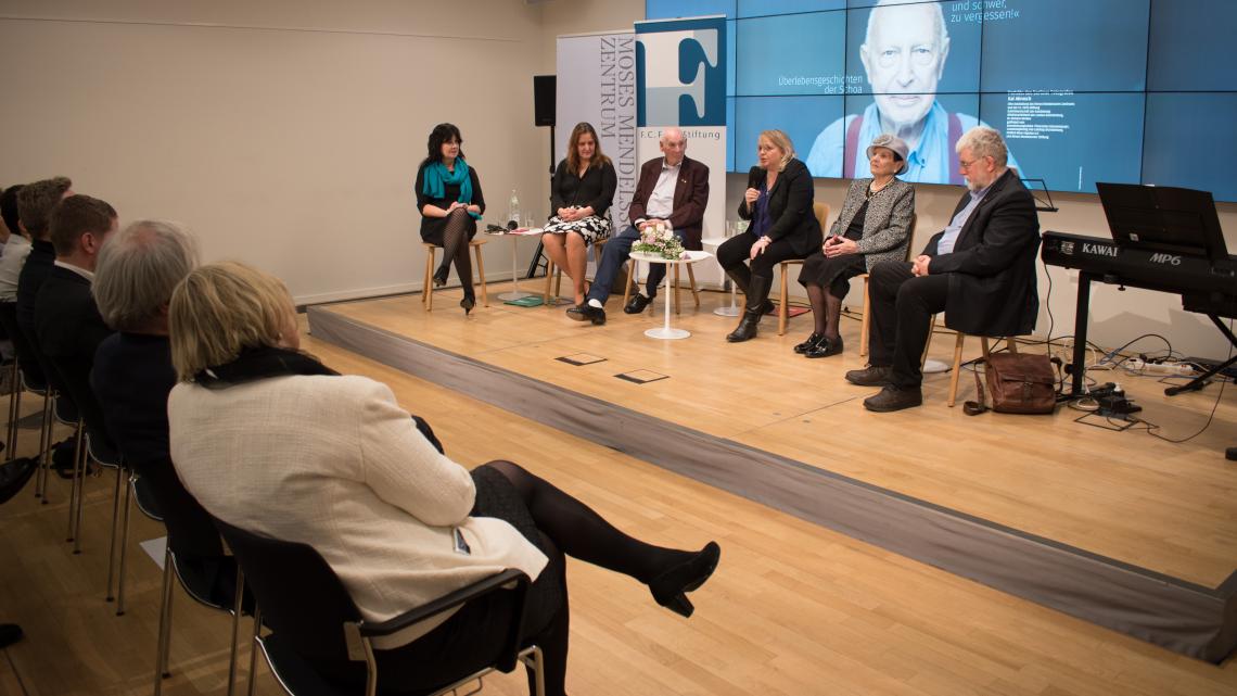 Podiumsdiskussion, v. l. n. r.: Direktorin des Luise-Henriette-Gymnasiums Oranienburg Gudrun Schiebe; Ministerin für Wissenschaft, Forschung und Kultur Dr. Manja Schüle; Zeitzeuge George Shefi; Moderatorin Susanne Krause-Hinrichs; Zeitzeugin Zipora Feiblowitsch und Pfarrer Rudi-Karl Pahnke vom Institut Neue Impulse 