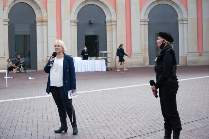 Landtagspräsidentin Prof. Dr. Ulrike Liedtke (l.) begrüßt die Künstlerinnen und Künstler sowie die Gäste zur letzten Veranstaltung „Kunst zur Zeit“ im Innenhof des Landtages.