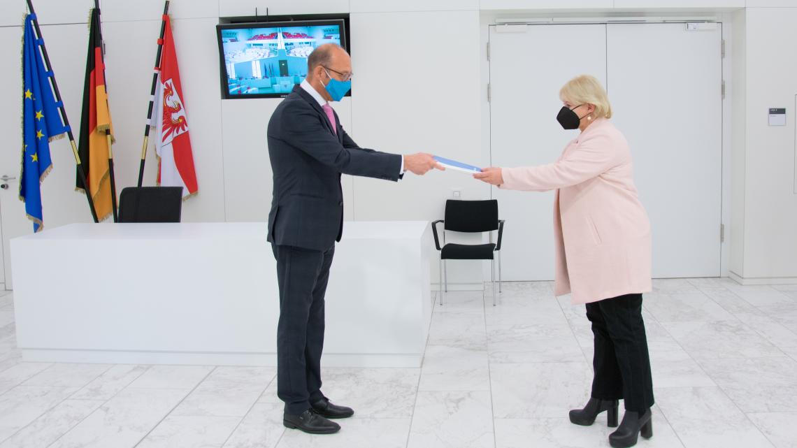 Landtagspräsidentin Prof. Dr. Ulrike Liedtke (r.) nimmt den Jahresbericht vom Präsidenten des Rechnungshofes Christoph Weiser (l.) entgegen.