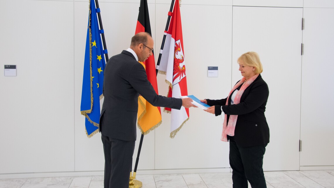 Landtagpräsidentin Prof. Dr. Ulrike Liedtke (r.) nimmt den Jahresbericht 2021 vom Präsidenten des Landesrechnungshofes Christoph Weiser (l.) entgegen.