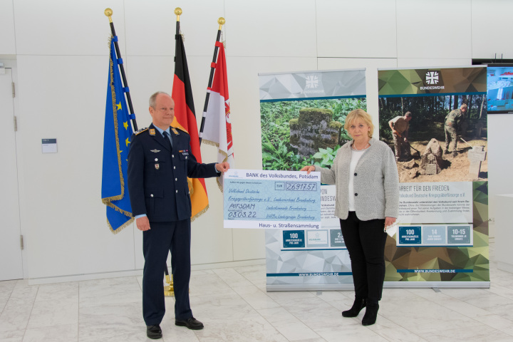 Der Kommandeur des Landeskommandos Brandenburg Oberst Olaf Detlefsen (l.) übergibt den Scheck der Haus- und Straßensammlung an Landtagspräsidentin Prof. Dr. Ulrike Liedtke (r.) 