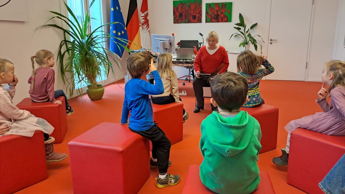Landtagspräsidentin Prof. Dr. Ulrike Liedtke liest Kita-Kindern aus Potsdam eine selbstgeschriebene Geschichte vor.