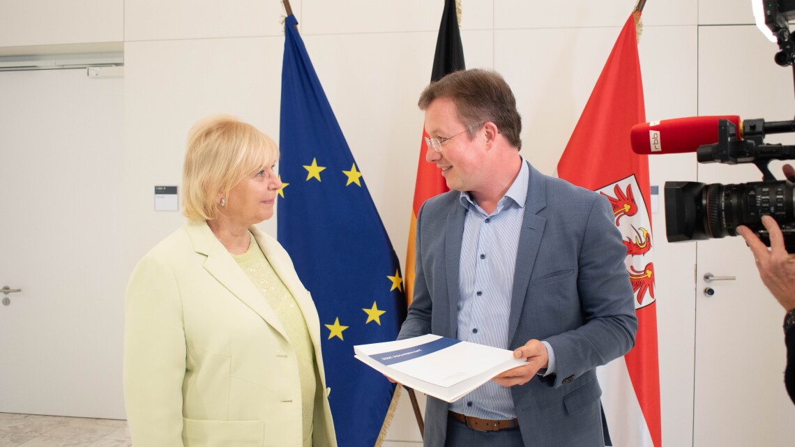 Landtagspräsidentin Prof. Dr. Ulrike Liedtke (l.) nimmt den Jahresbericht 2025 vom Präsidenten des Landesrechnungshofes Harald Kümmel (r.) entgegen.