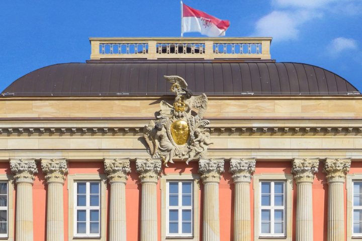 Adler an der südlichen Außenfassade und auf der Flagge des Gebäudes