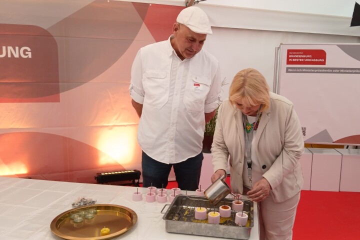 Landtagspräsidentin Prof. Dr. Ulrike Liedtke (r.) beim Kerzen gießen mit Imker Holger Ackermann (l.) vom Landesimkerverband Brandenburg