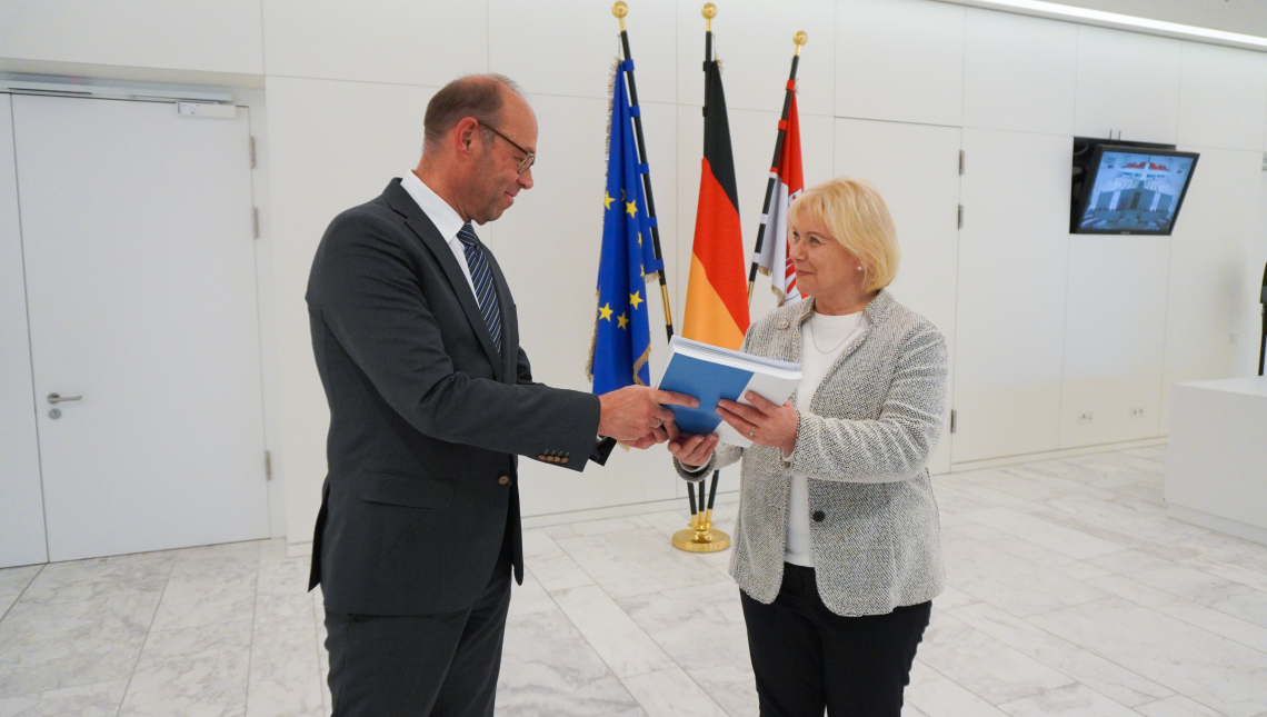 Landtagspräsidentin Prof. Dr. Ulrike Liedtke (r.) nimmt den Jahresbericht des Landesrechungshofes von dessen Präsidenten Christoph Weiser (l.) entgegen.