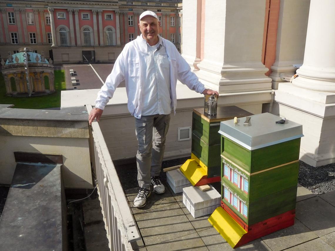 Imker Holger Ackermann bringt die zwei Bienenbeuten auf das Dach des Fortunaportals.