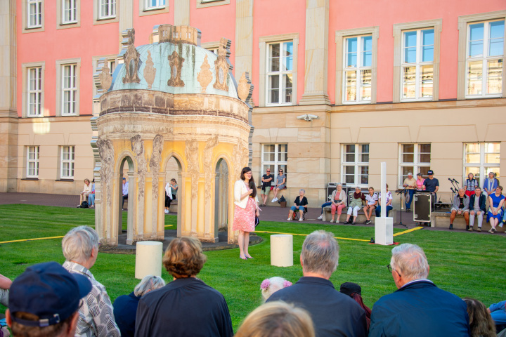 Landtagsvizepräsidentin Dr. Jouleen Gruhn begrüßt Teo Vadersen und Stephan Schill vom Theater Poetenpack und die Gäste zur fünften Veranstaltung „Kunst zur Zeit 2025“ im Innenhof des Landtages.