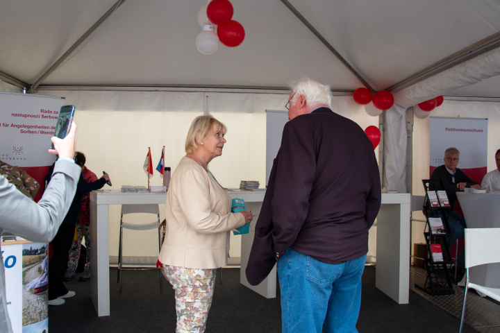 Landtagspräsidentin Prof. Dr. Ulrike Liedtke (l.) im Gespräch mit einem Bürger im Zelt des Landtages Brandenburg.
