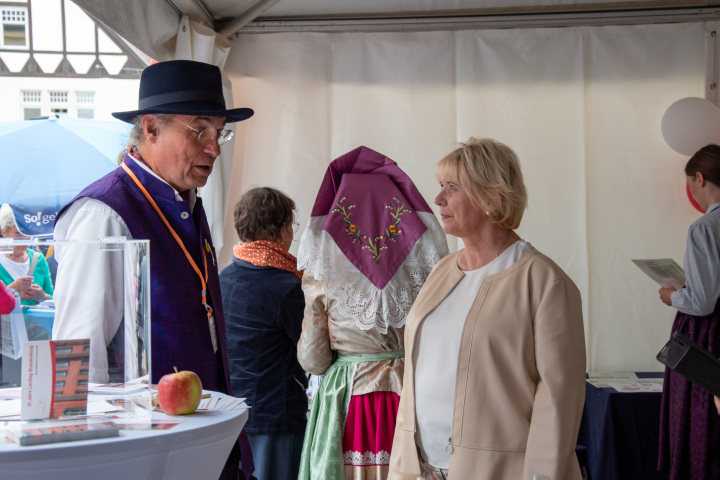 Landtagspräsidentin Prof. Dr. Ulrike Liedtke (r.) im Gespräch mit einem Bürger im Zelt des Landtages.