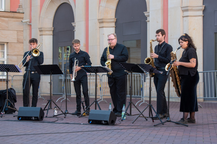 Posaunist Benedikt Kalinke (1. v. l.), Trompeter Hans Wohlfahrt (2. v. l.), Altsaxophonist Jonas Lenz (3. v. l.), Tenorsaxophonist Edgar Neumann (4. v. l.) und Baritonsaxophonistin Ada Greifenhahn (5. v. l.) beim Auftritt des Landesjugendjazzorchesters Brandenburg im Innenhof des Landtages