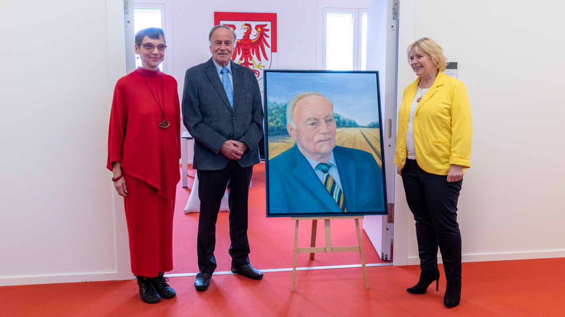 Landtagspräsidentin Prof. Dr. Ulrike Liedtke (r.) mit dem ehemaligen Parlamentspräsidenten Gunter Fritsch (m.) und der Potsdamer Künstlerin Katrin Seifert (l.) vor dem Porträt von Gunter Fritsch