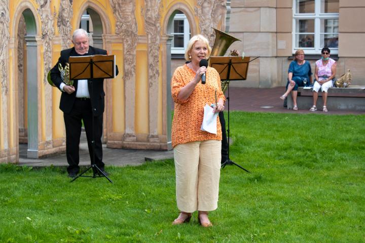 Landtagspräsidentin Prof. Dr. Ulrike Liedtke (m.) begrüßt die Gäste zur vierten Veranstaltung „Kunst zur Zeit“ im Innenhof des Landtages. 