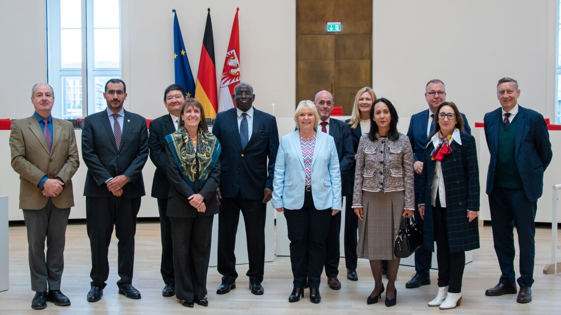 Gemeinsames Gruppenfoto der Diplomaten mit der Landtagspräsidentin Prof. Dr. Ulrike Liedtke (6. v. l.), Landtagsvizepräsident Rainer Genilke (3. v. r.), dem BSW-Fraktionsvorsitzenden Niels-Olaf Lüders (7. v. l.) und der SPD-Abgeordneten Melanie Balzer (8. v. l.).