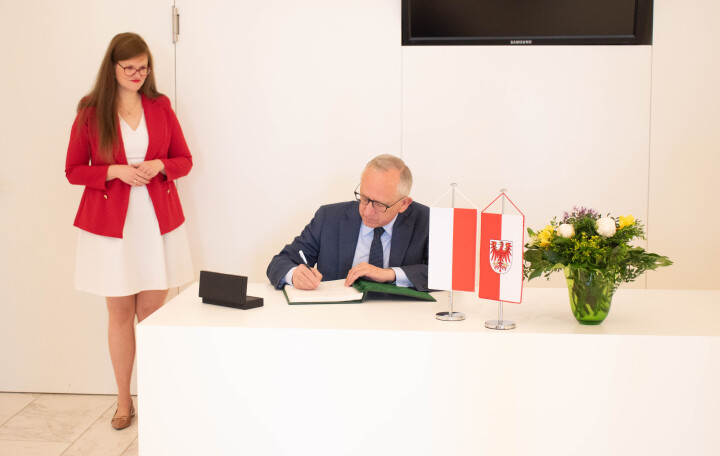 Der Geschäftsträger (a.i.) der polnischen Botschaft Jan Tombiński (r.) trägt sich, im Beisein der Vizepräsidentin Dr. Jouleen Gruhn (l.), ins Gästebuch des Landtages ein. 