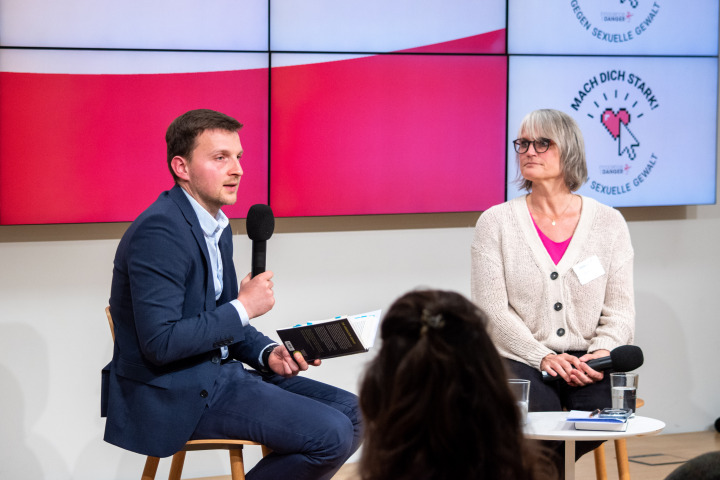 Autor Daniel Moßbrucker (l.) liest im Rahmen des Gespräches einzelne Passagen aus seinem Buches „Direkt vor unserem Auge: Wie Pädokriminelle im Internet vorgehen - und wie wir Kinder davor schützen“ vor.