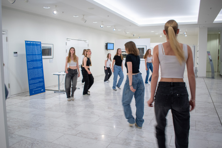 Tänzerische Interventionen in der Ausstellung mit Schülerinnen des Friedrich-Gymnasiums Luckenwalde. Die Schülerinnen interagieren mit einzelnen Fotos im Ausstellungsraum.