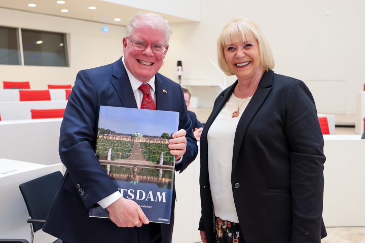 Landtagspräsidentin Prof. Dr. Ulrike Liedtke (r.) überreicht ein Buch über Potsdam an den Gesandten Woodward Clarke Price (l.)
