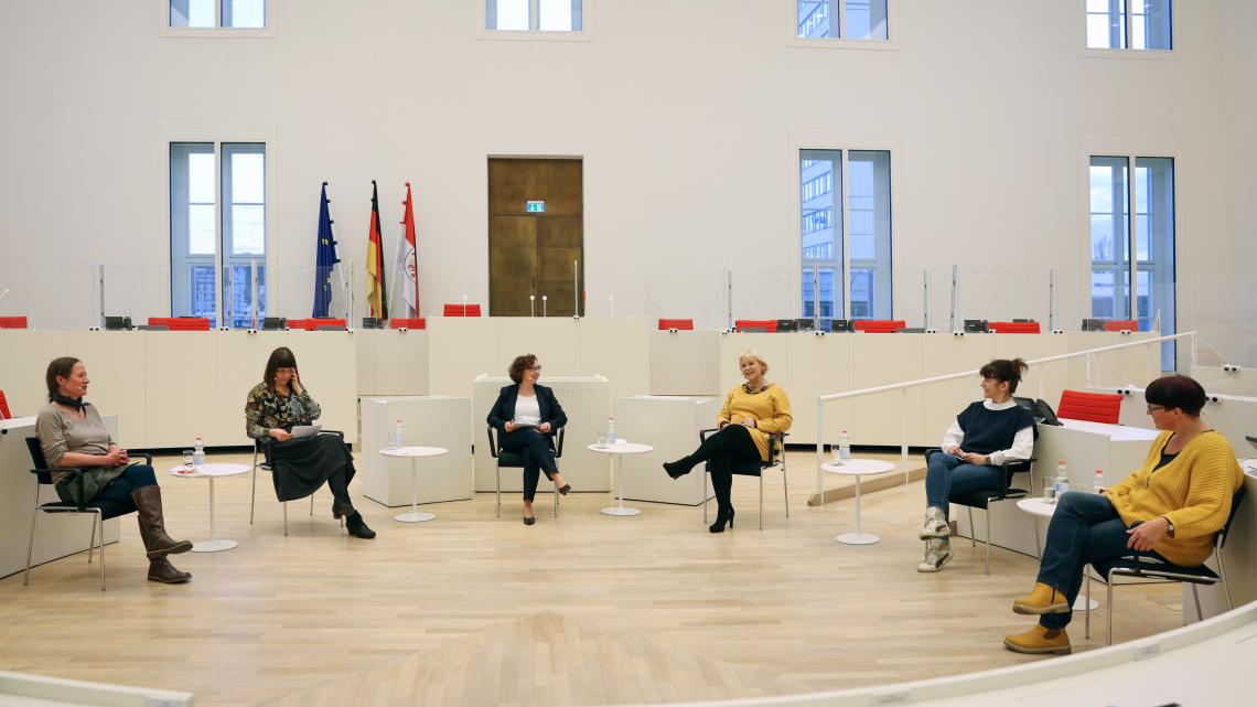 Die Teilnehmerinnen der Podiumsdiskussion (v. l. n. r.) Michaela Rönnefarth vom Frauenhaus Neuruppin, die Sprecherin des Frauenpolitischen Rates Christiane Bonk, die Landesgleichstellungsbeauftrage Manuela Dörnenburg, die Landtagspräsidentin Prof. Dr. Ulrike Liedtke, Marita Erxleben von der Tanzakademie Erxleben Potsdam und Martina Büttner, Chorleiterin und Beisitzerin im Brandenburgischen Chorverband e. V. im Plenarsaal. 