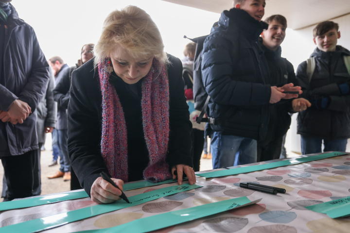 Landtagspräsidentin Prof. Dr. Ulrike Liedtke schreibt eine Antwort auf die Frage "Warum erinnerst du dich heute? auf ein Klebeband.