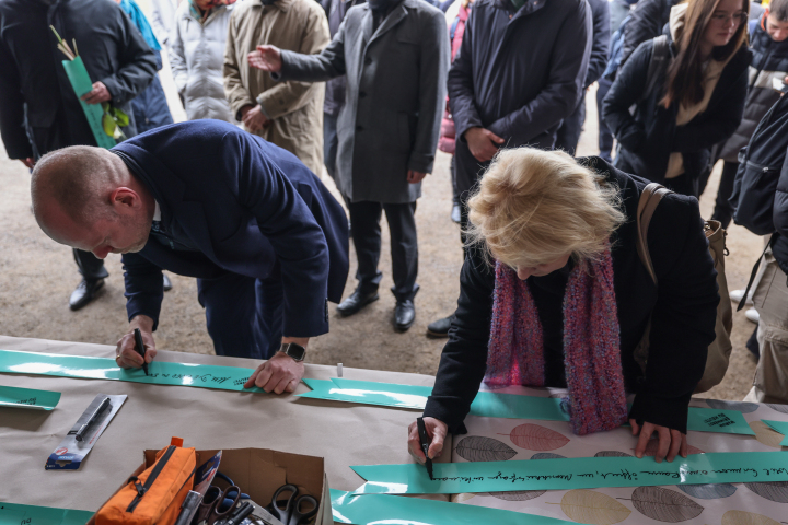 Landtagspräsidentin Prof. Dr. Ulrike Liedtke und der Direktor der Stiftung Brandenburgische Gedenkstätten Dr. Axel Drecoll schreiben eine Antwort auf die Frage "Warum erinnerst du dich heute? auf ein Klebeband.