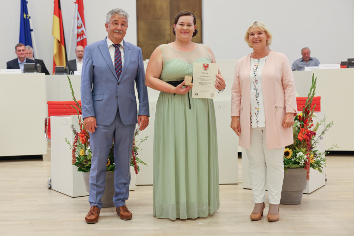 Übergabe der Medaille und Urkunde an die zu Ehrende Aileen Huhnstock (m.) 