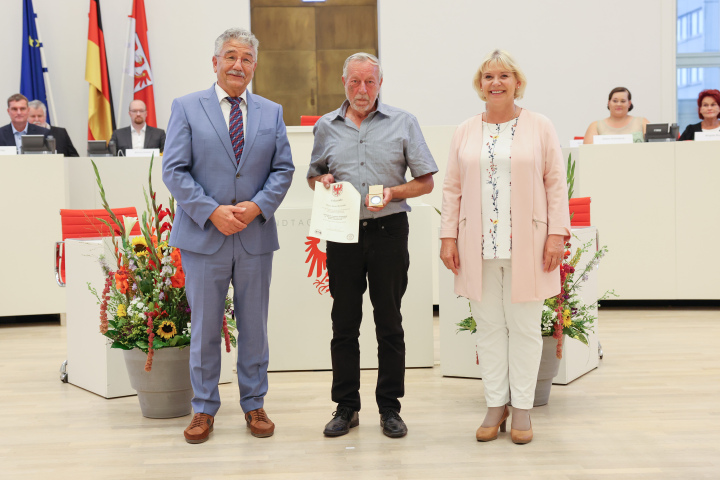 Übergabe der Medaille und Urkunde an den zu Ehrenden Bernd Kosensky (m.)