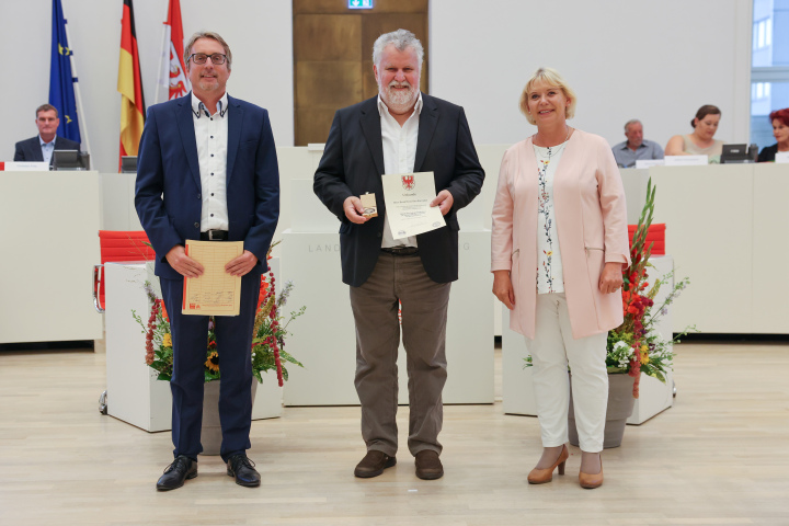 Übergabe der Medaille und Urkunde an den zu Ehrenden Bernd Heinz Karwinkel (m.)