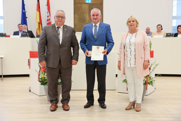 Übergabe der Medaille und Urkunde an den zu Ehrenden Christoph Malcherowitz (m.)