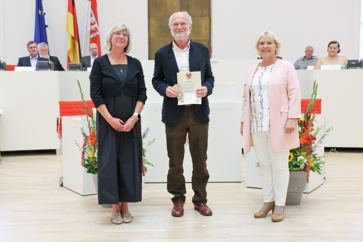 Übergabe der Medaille und Urkunde an den zu Ehrenden Robert Volkmann (m.)