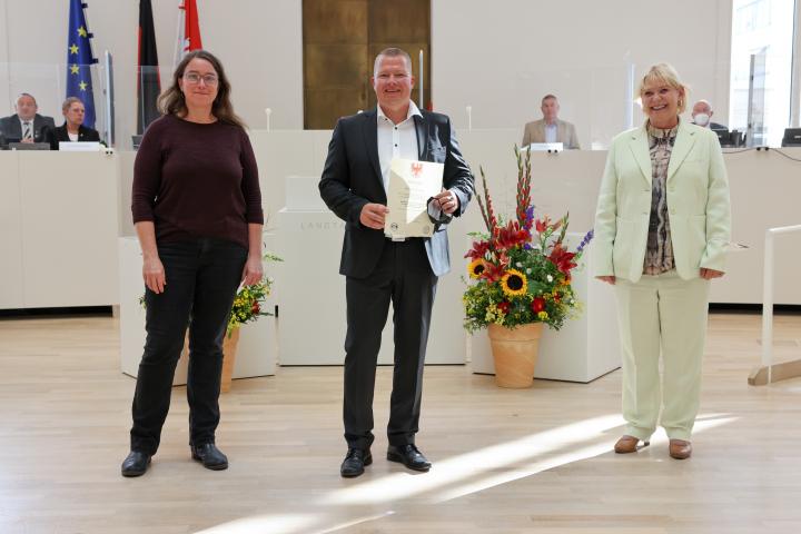 Übergabe der Medaille und Urkunde an den zu Ehrenden Rayk Sommer (m.)