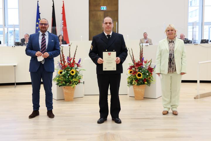 Übergabe der Medaille und Urkunde an den zu Ehrenden Oberstabsgefreiter Steven Bölke (m.)