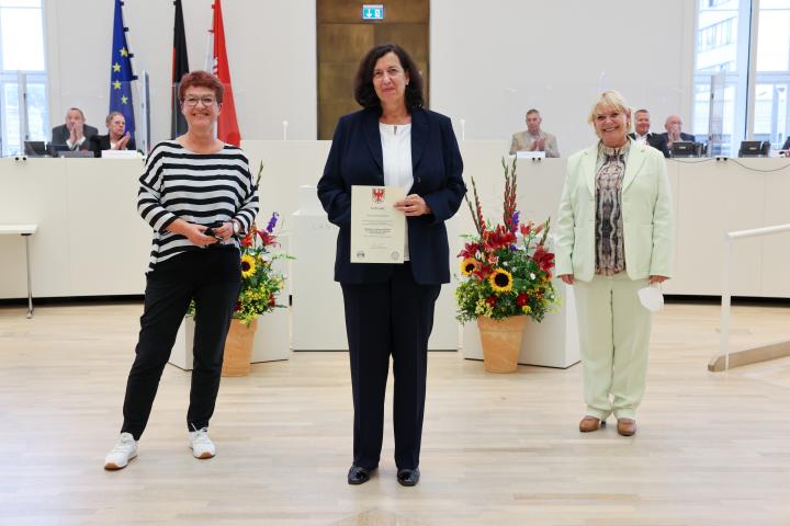 Übergabe der Medaille und Urkunde an die zu Ehrende Carola Christen (m.)