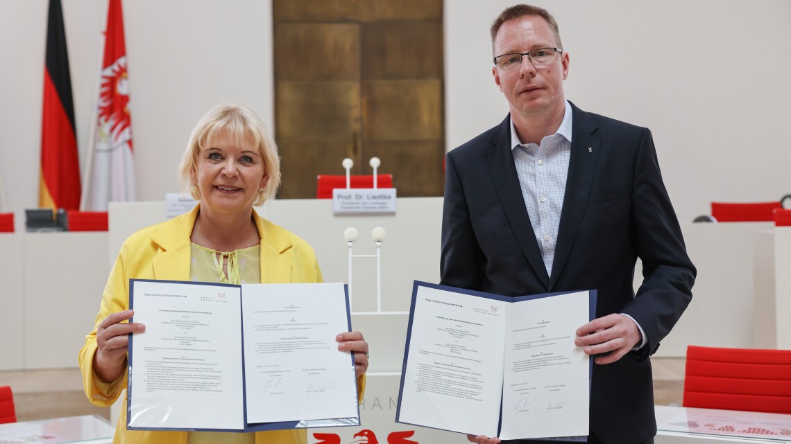 Landtagspräsidentin Prof. Dr. Liedtke (l.) und der Präsident des Abgeordnetenhauses von Berlin, Dennis Buchner (r.), mit der unterzeichneten Verwaltungsvereinbarung zur Zusammenarbeit in der Parlamentarischen Konferenz im Plenarsaal des Landtages Brandenburg