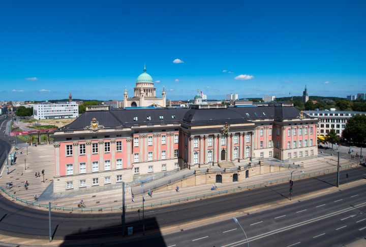 Gebäude von Süden, im Hintergrund die markanten grünen Kuppeln der St. Nikolaikirche und des Alten Rathauses